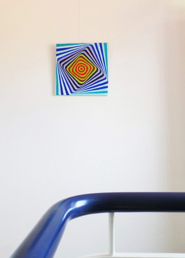 Bunte geometrische Kunst mit spiralförmigem Muster an einer weißen Wand. https://yamakawa.eu/direct-sales-stripes-gallery/turn-me/
