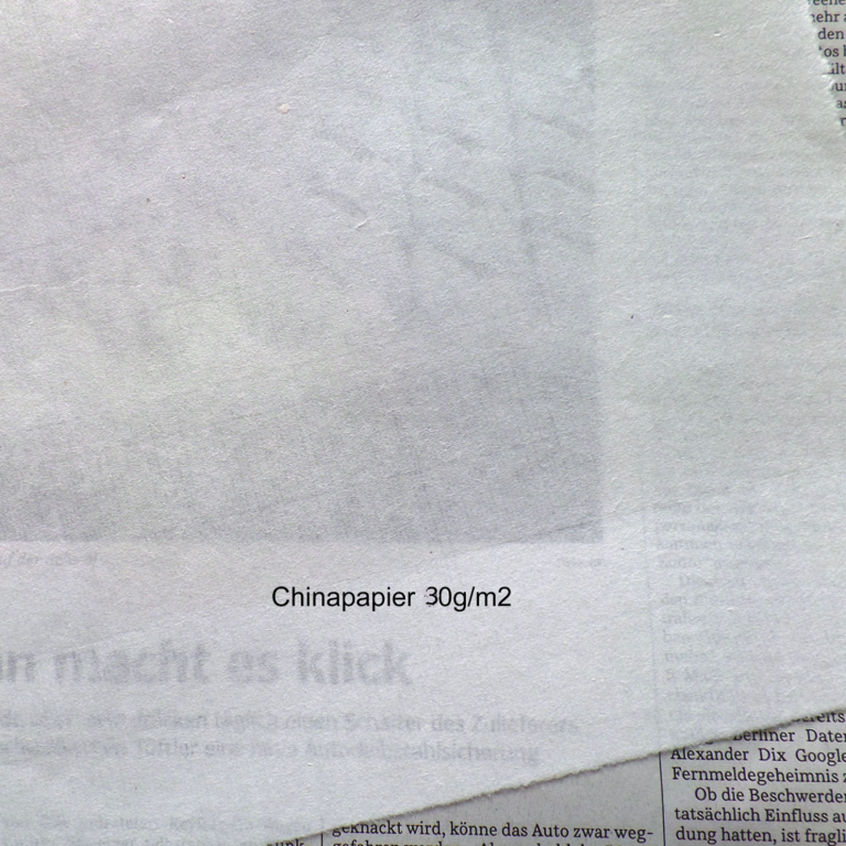 Durch dünnes Chinapapier kann er darunterliegende Zeitungsartikel lesen.