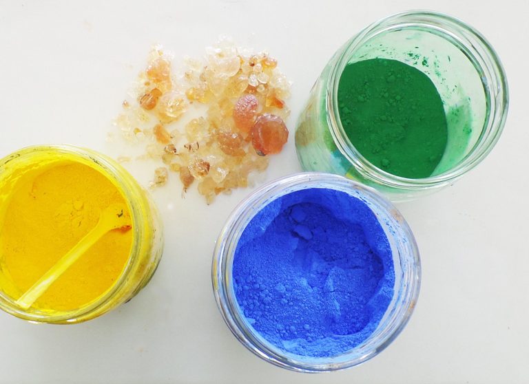 Drei Gläser mit Farbpulver (Gelb, Blau, Grün) und paar Stücke Gumiarabikum.